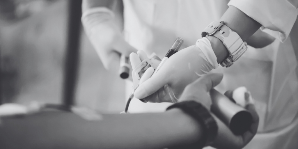 Someone donating blood in a greyscale image