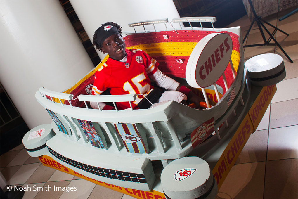 Young boy in a wheelchair designed to be a Chiefs stadium costume