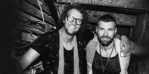 For King + Country Liam and Joel smiling in a greyscale image